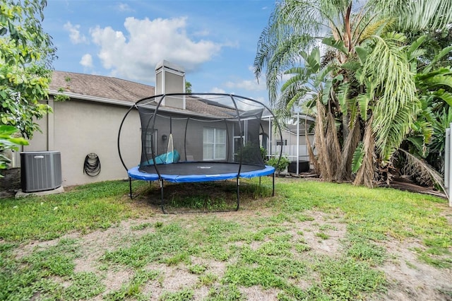 view of yard featuring central AC unit and a trampoline