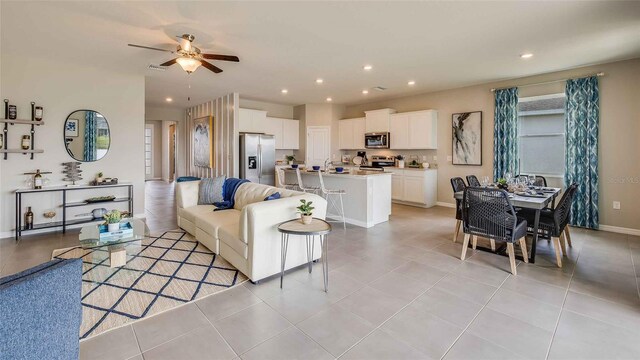 living room featuring ceiling fan and light tile patterned floors