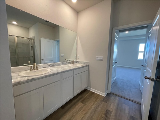 bathroom with hardwood / wood-style floors, vanity, and walk in shower