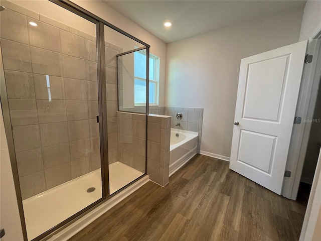 bathroom featuring wood-type flooring and independent shower and bath