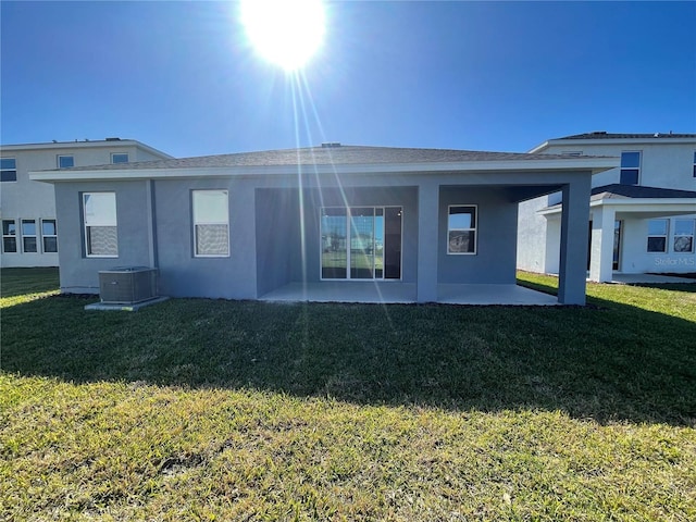 rear view of house featuring a patio area, a yard, and central AC