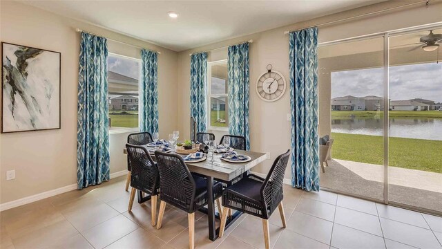 dining room featuring a water view and light tile patterned floors