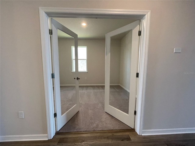 hall with hardwood / wood-style floors and french doors