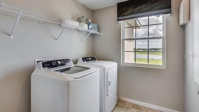 clothes washing area with washing machine and clothes dryer and light tile patterned floors