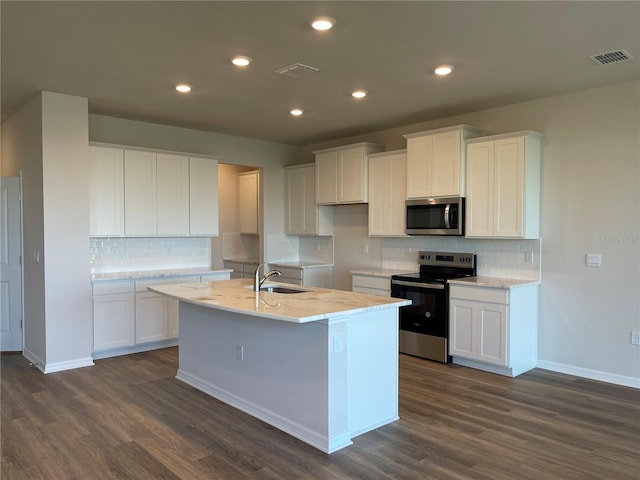 kitchen with stainless steel appliances, white cabinetry, dark hardwood / wood-style floors, and a kitchen island with sink