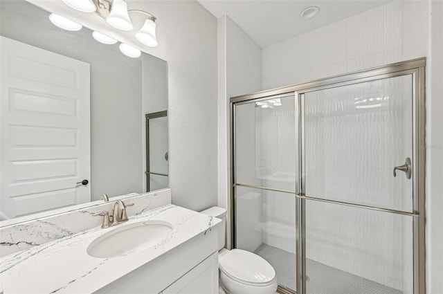 bathroom featuring vanity, toilet, and a shower with door