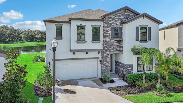 view of front of house featuring a water view, a garage, and a front lawn