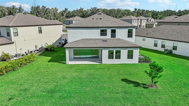 rear view of property featuring a yard, cooling unit, and a patio area