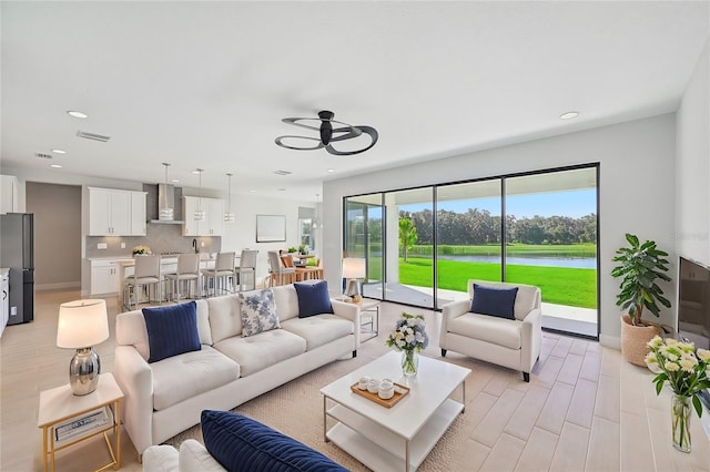 living room featuring light hardwood / wood-style flooring and ceiling fan