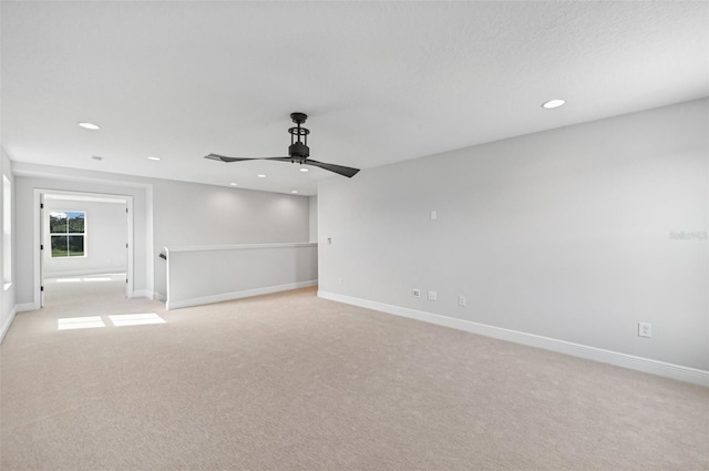 carpeted spare room featuring ceiling fan