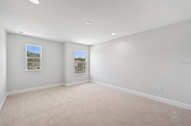 unfurnished room with light carpet and a textured ceiling