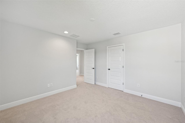 carpeted empty room featuring a textured ceiling