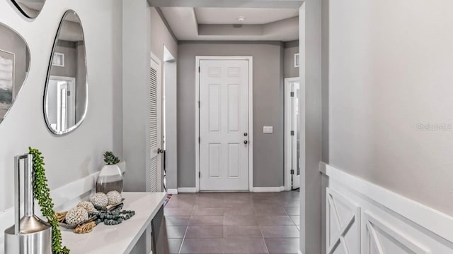 interior space featuring a tray ceiling and dark tile patterned floors