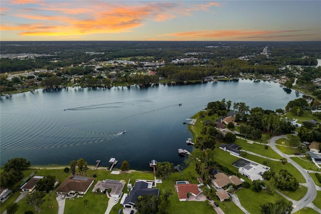 aerial view at dusk featuring a water view