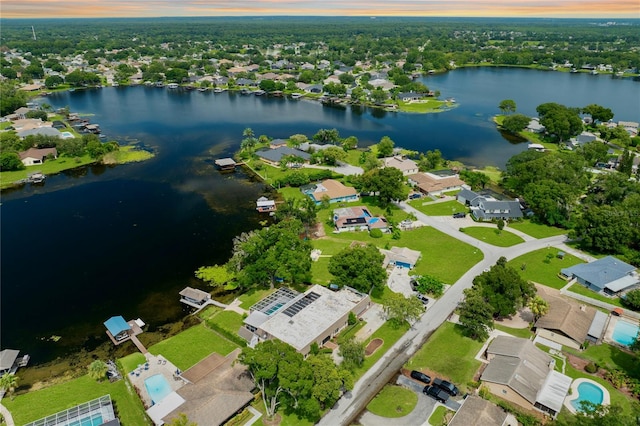 aerial view at dusk featuring a water view