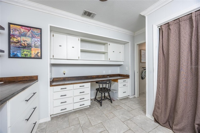 office space featuring crown molding, built in desk, and a textured ceiling