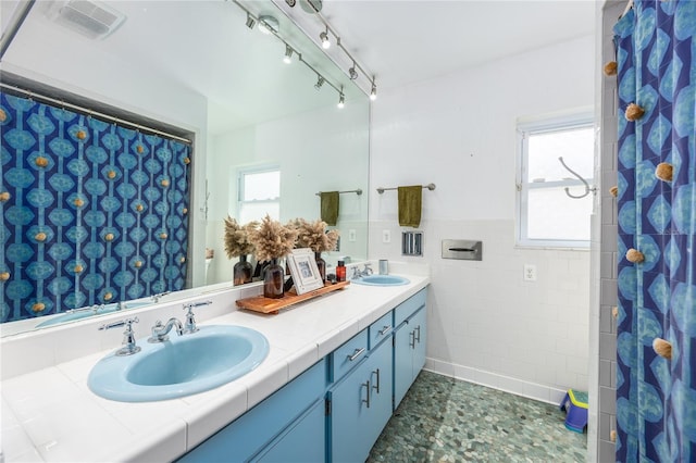 bathroom featuring plenty of natural light, tile walls, and vanity