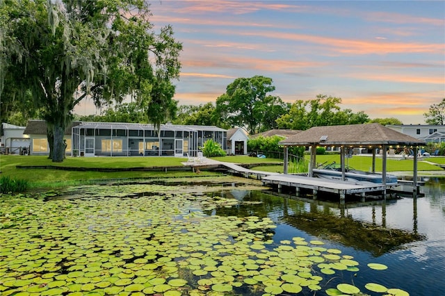 dock area with a lawn and a water view