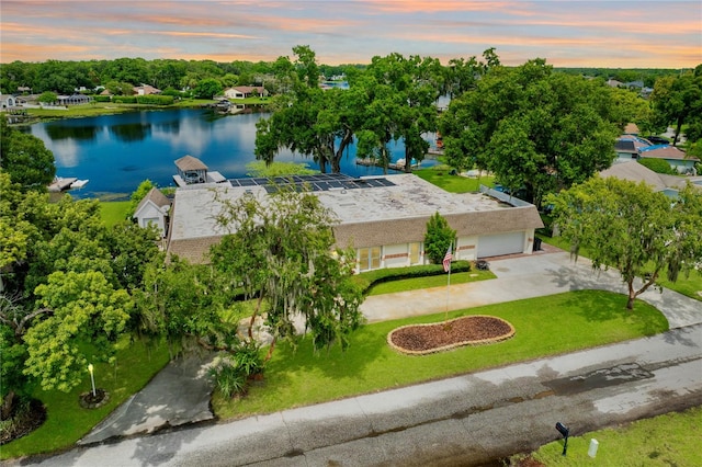 aerial view at dusk featuring a water view