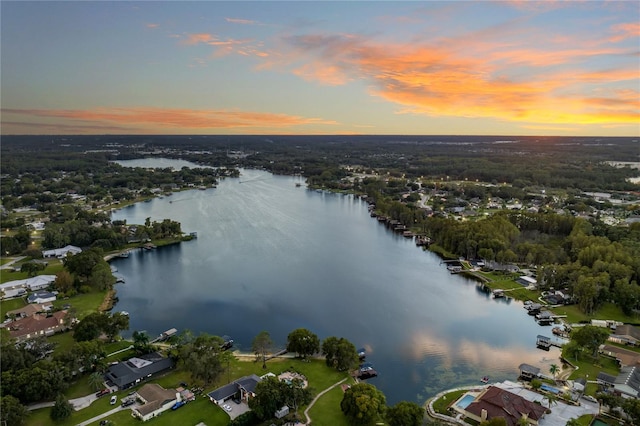 aerial view at dusk featuring a water view