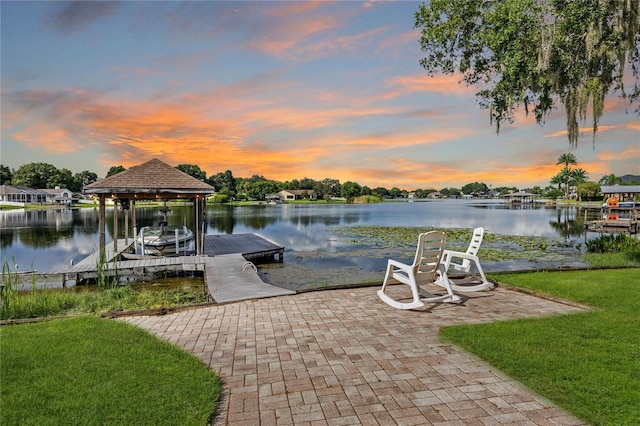 view of dock with a yard and a water view