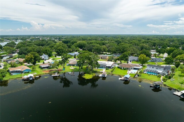 drone / aerial view with a water view, a residential view, and a view of trees