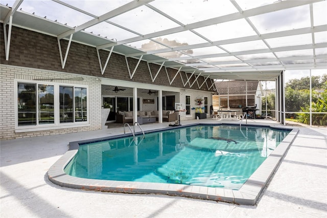 pool featuring a lanai, a patio area, outdoor lounge area, and a ceiling fan