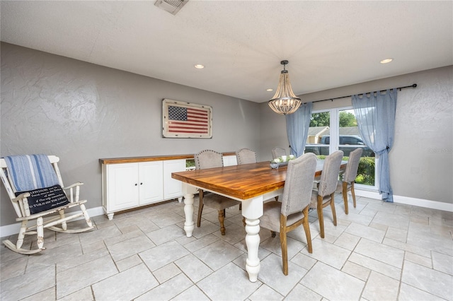 dining space with a textured wall, recessed lighting, visible vents, baseboards, and an inviting chandelier