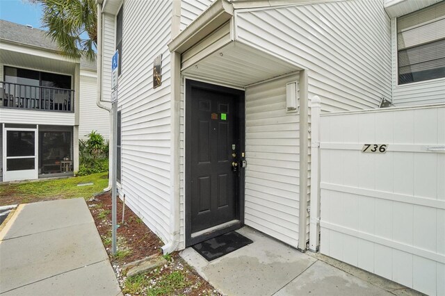 view of exterior entry with a balcony