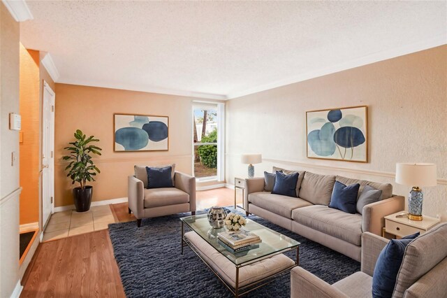 living room with a textured ceiling, light hardwood / wood-style flooring, and ornamental molding