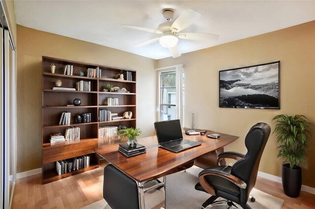 office with light hardwood / wood-style floors and ceiling fan