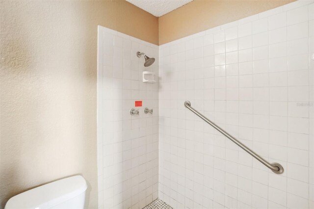 bathroom with tiled shower and toilet