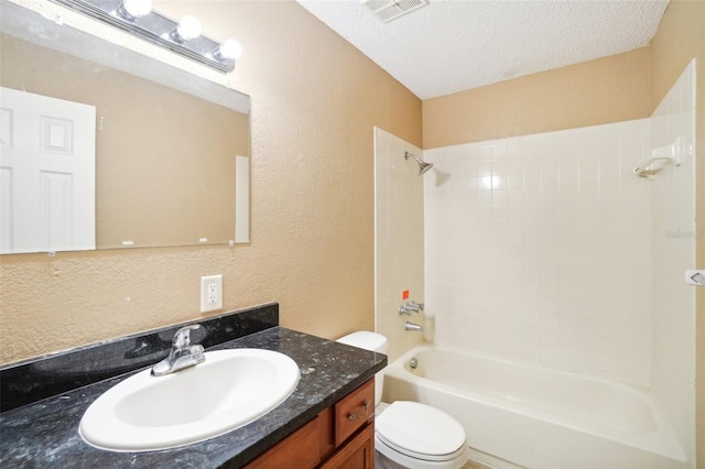 full bathroom featuring vanity, a textured ceiling, tiled shower / bath combo, and toilet