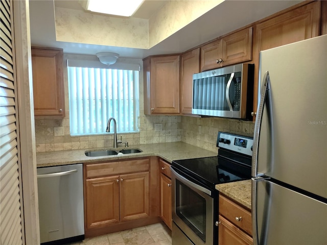 kitchen with light tile patterned flooring, stainless steel appliances, decorative backsplash, sink, and light stone counters