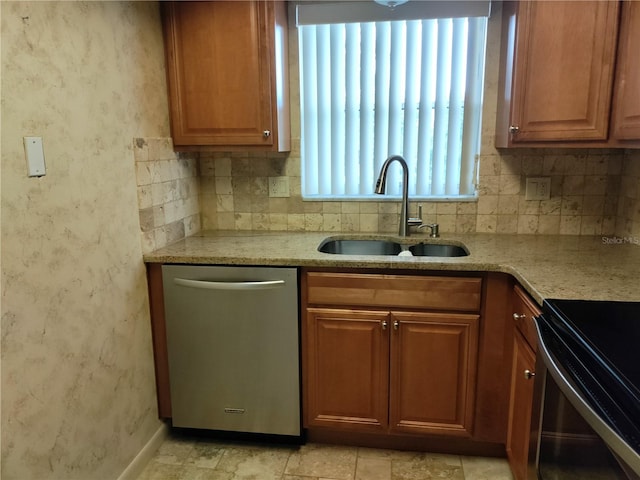 kitchen featuring light tile patterned flooring, light stone counters, stainless steel dishwasher, decorative backsplash, and sink