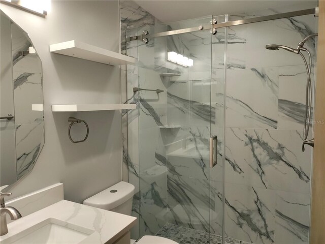 bathroom with vanity, an enclosed shower, and toilet