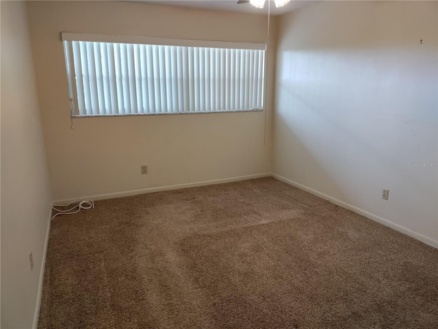 carpeted spare room featuring ceiling fan