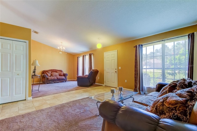 carpeted living room featuring lofted ceiling, a chandelier, and a textured ceiling