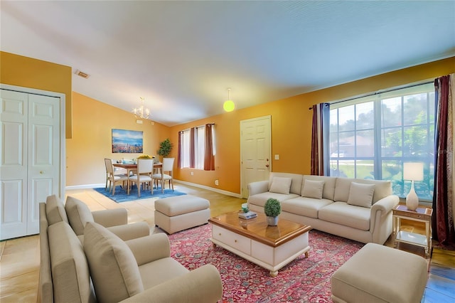 living room featuring lofted ceiling and a chandelier