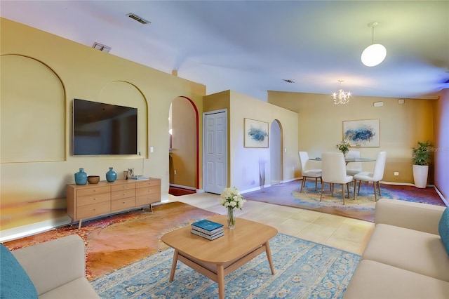 living room with vaulted ceiling, light tile patterned floors, and a chandelier