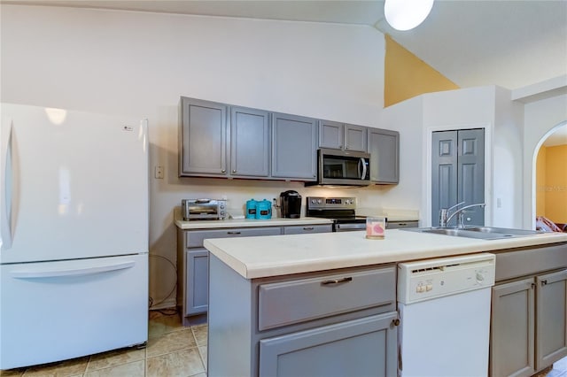 kitchen featuring light tile patterned floors, appliances with stainless steel finishes, sink, an island with sink, and high vaulted ceiling