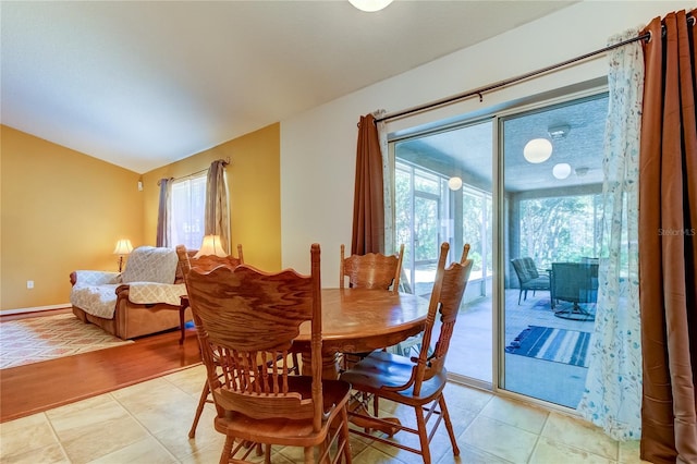 tiled dining area featuring lofted ceiling