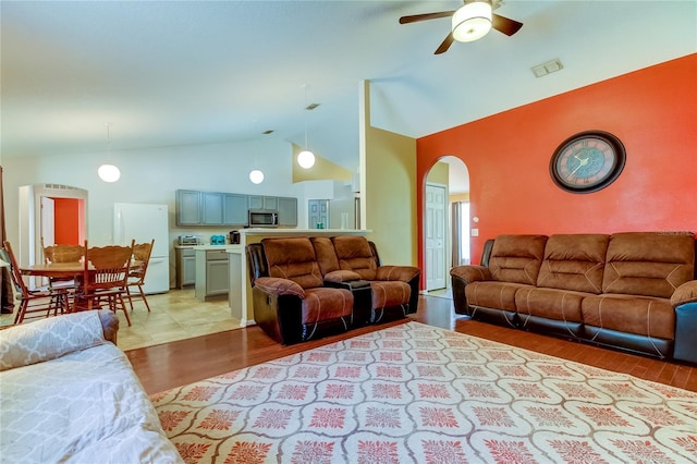 living room featuring vaulted ceiling, light wood-type flooring, and ceiling fan