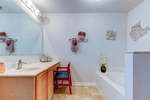 bathroom with vanity, a textured ceiling, a bathing tub, and tile patterned floors