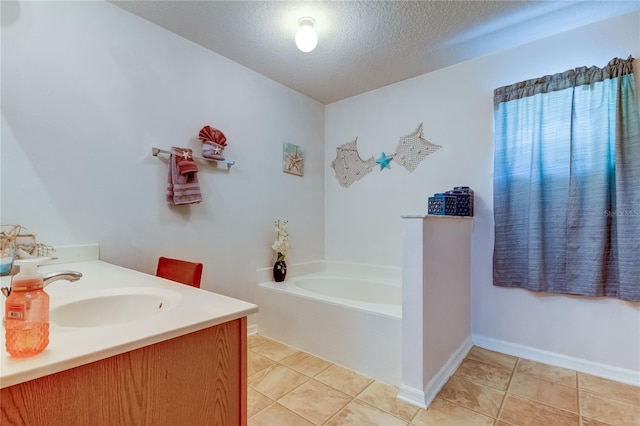 bathroom featuring a bath, tile patterned floors, vanity, and a textured ceiling