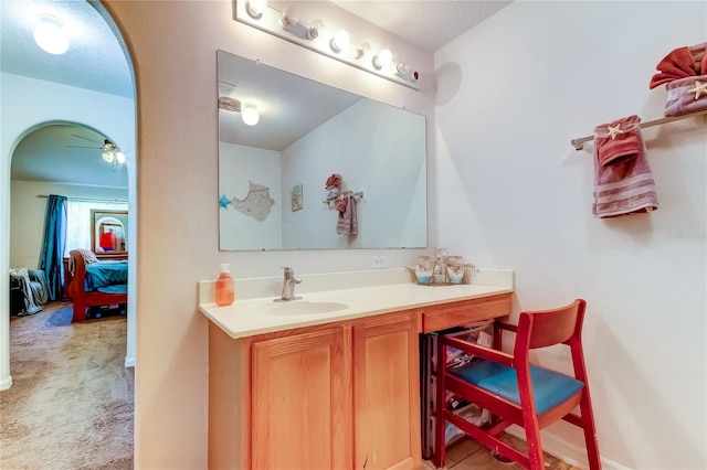 bathroom with a textured ceiling, vanity, and ceiling fan