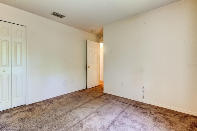 unfurnished bedroom with carpet flooring and a closet