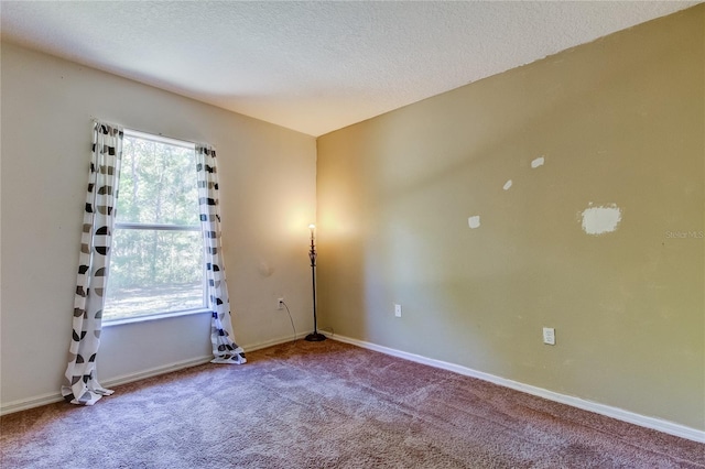 carpeted empty room with a textured ceiling