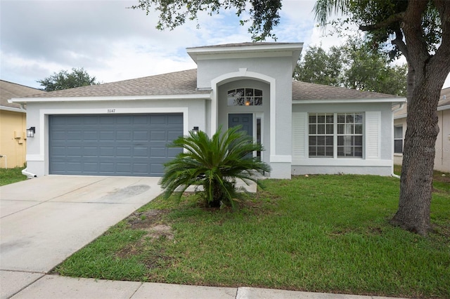 view of front of property with a front yard and a garage