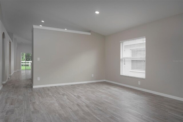 empty room featuring light hardwood / wood-style flooring and ornamental molding